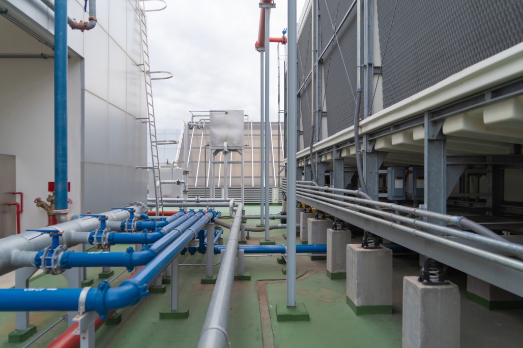 Cooling Tower Lifecycle - Cooling Tower and chiller unit on top of an office building with water pipes and connections